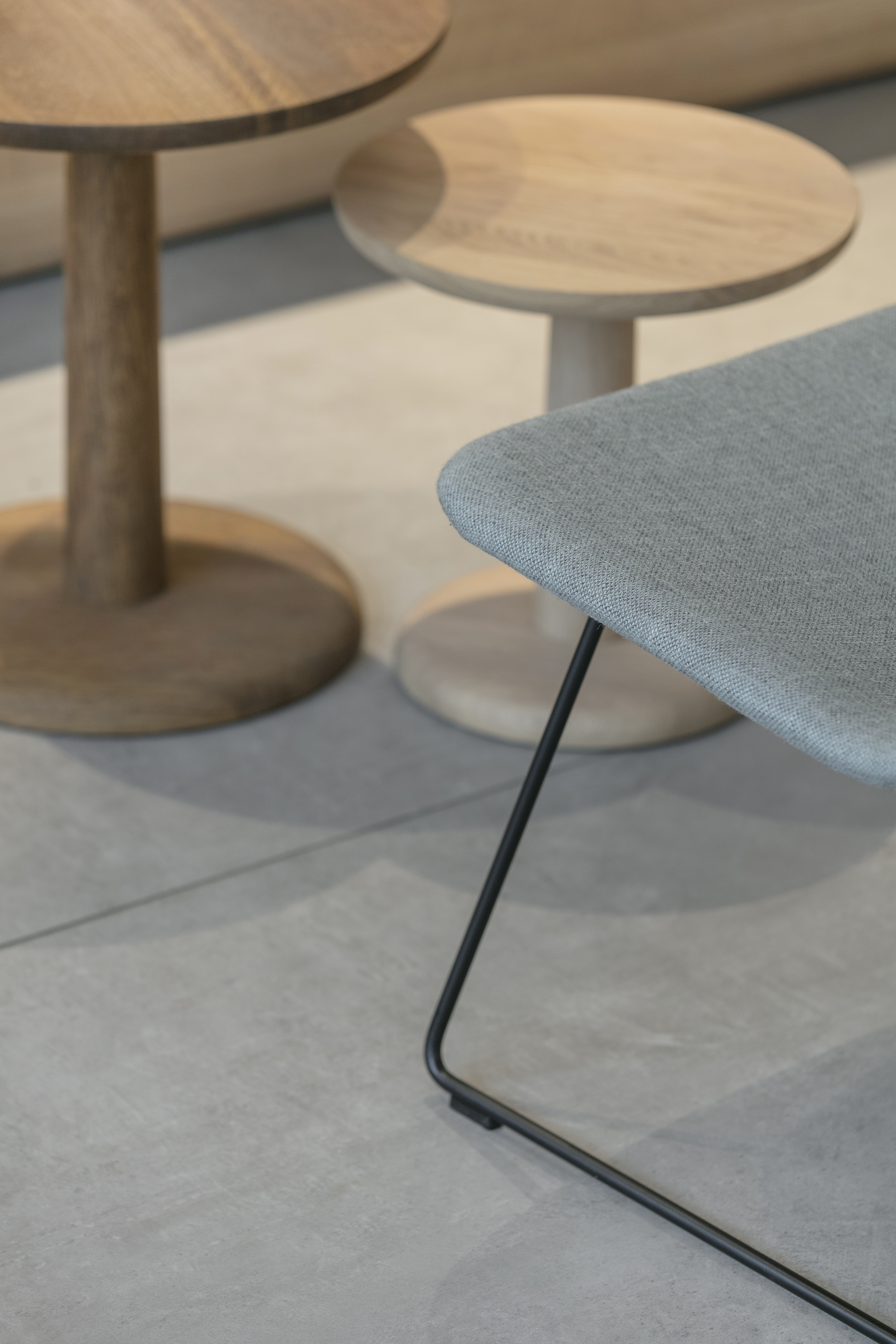Carreaux gris intérieurs haut de gamme avec tables d'appoint en bois modernes.