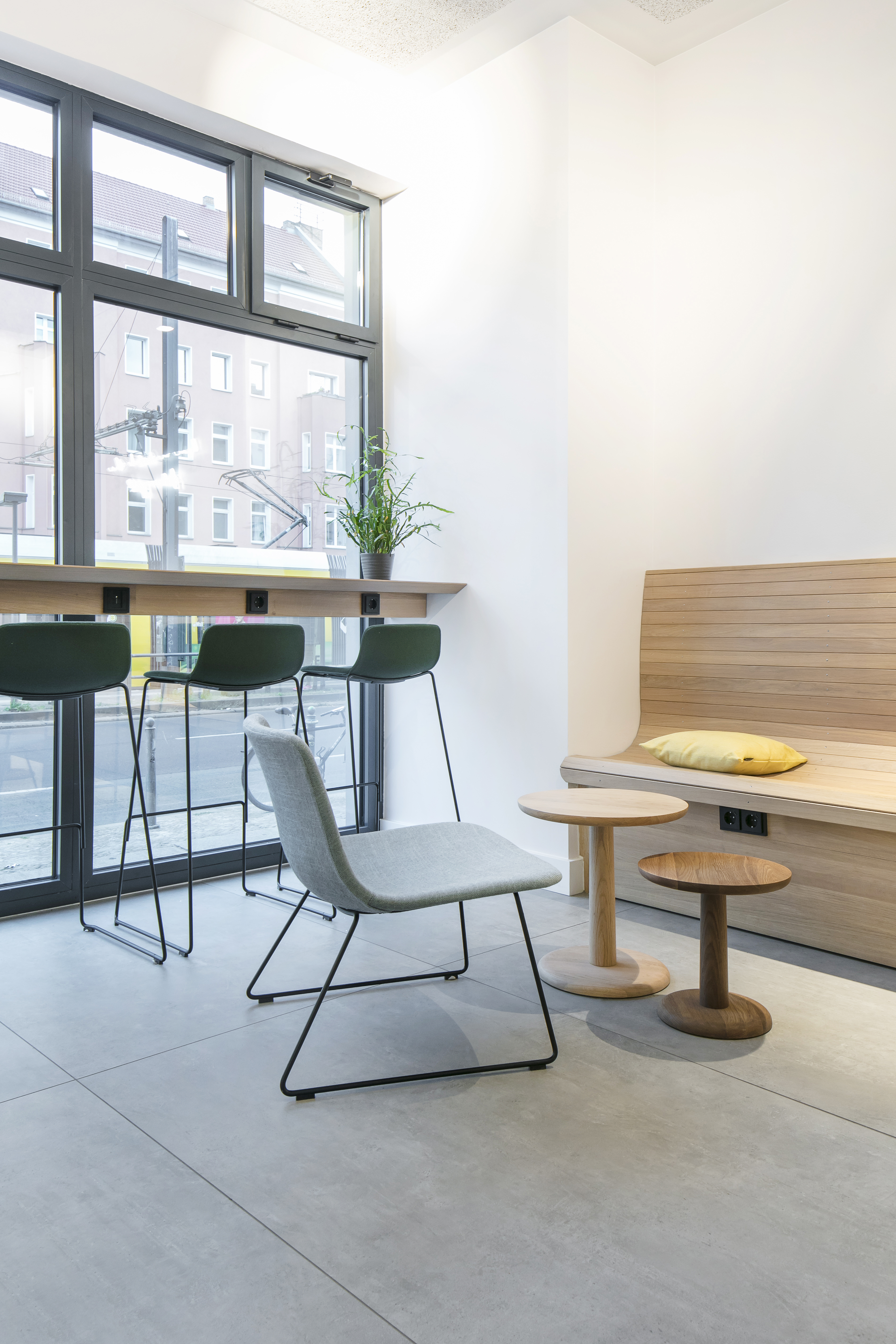 Carreaux clairs grand format dans un espace d'attente moderne avec éléments en bois.