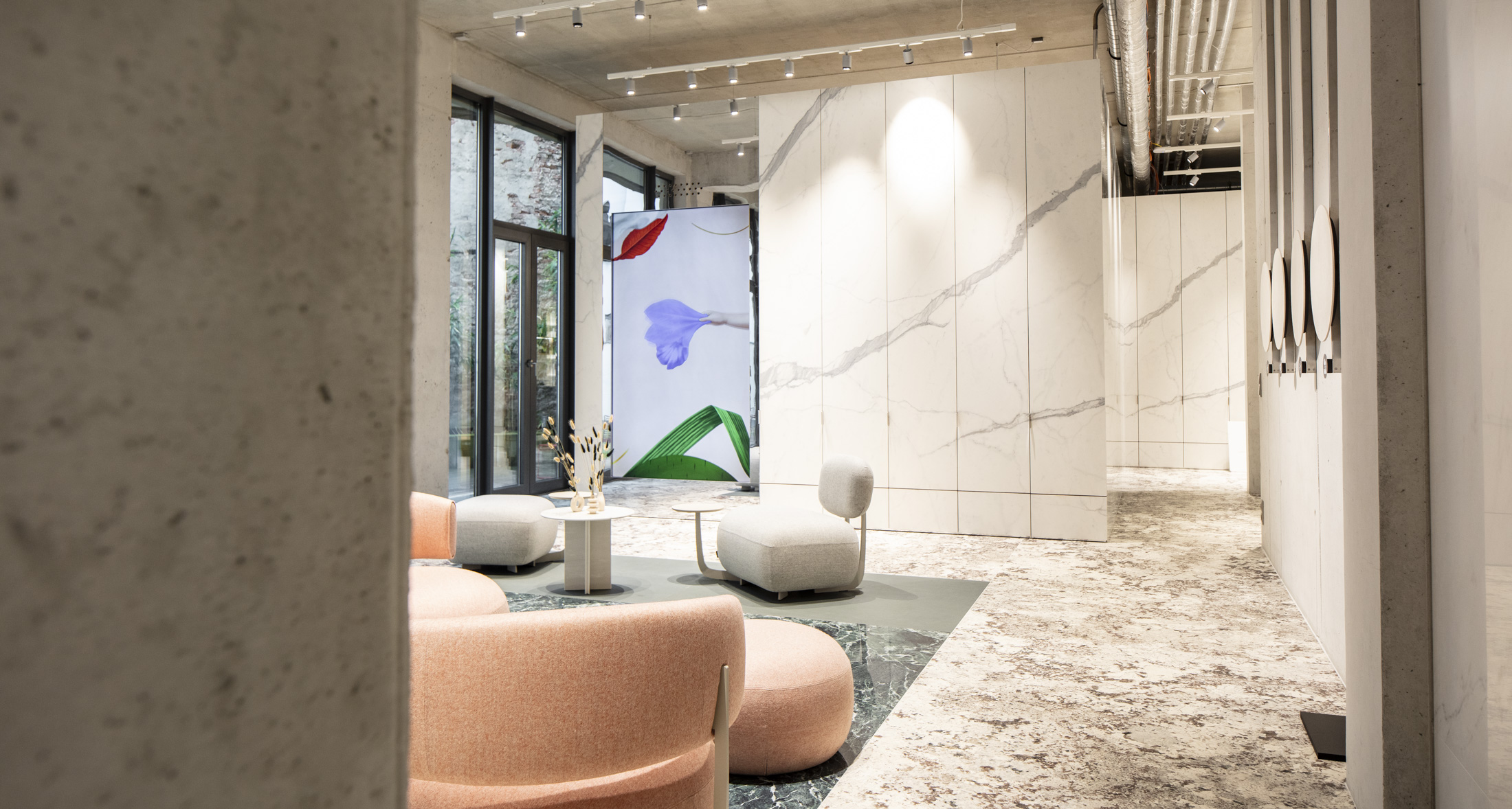 Pièce moderne, carrelage grand format marbre clair murs et sols, mobilier lounge élégant.