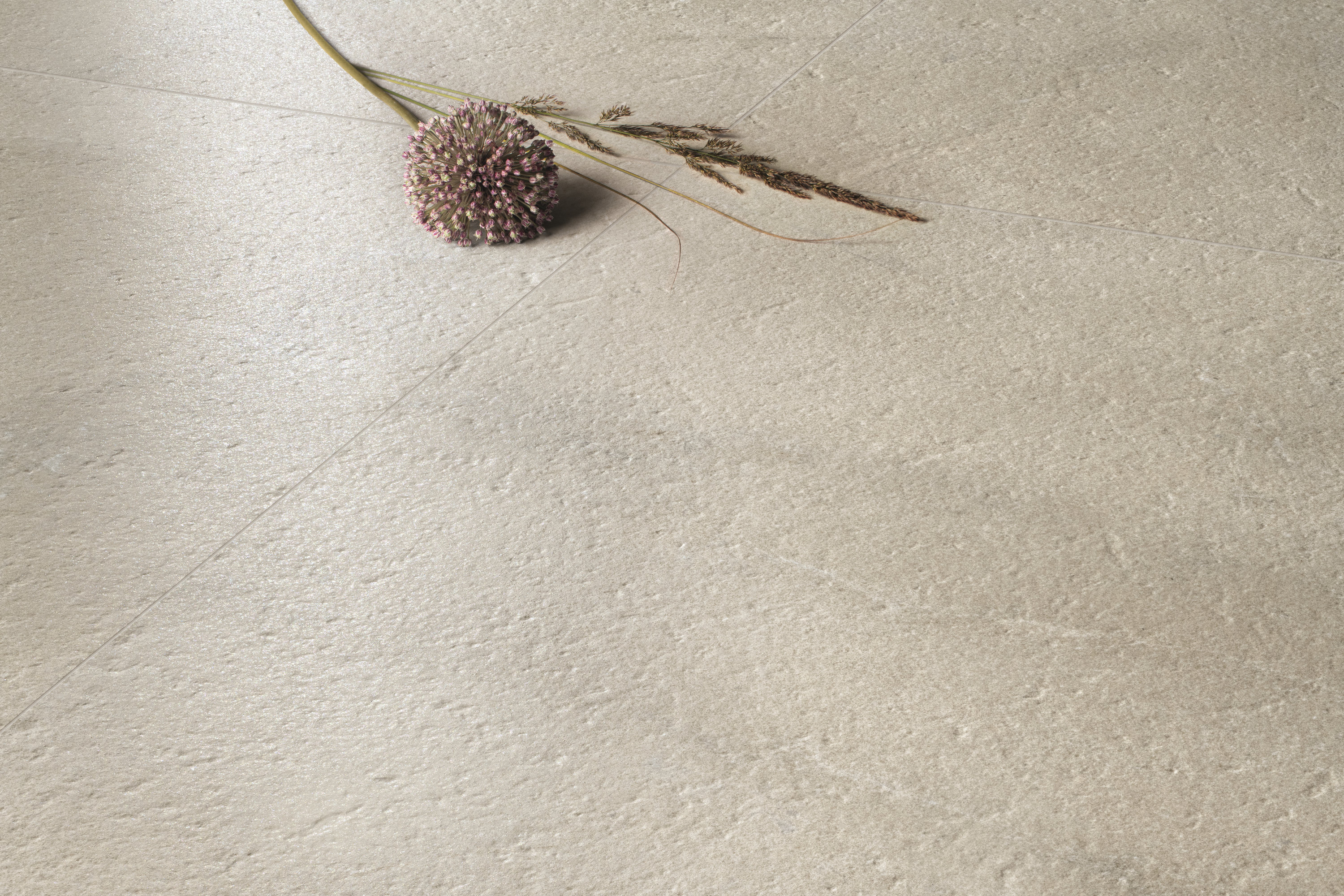 Carrelage en grès cérame de haute qualité, beige clair, aspect pierre naturelle et surface mate.