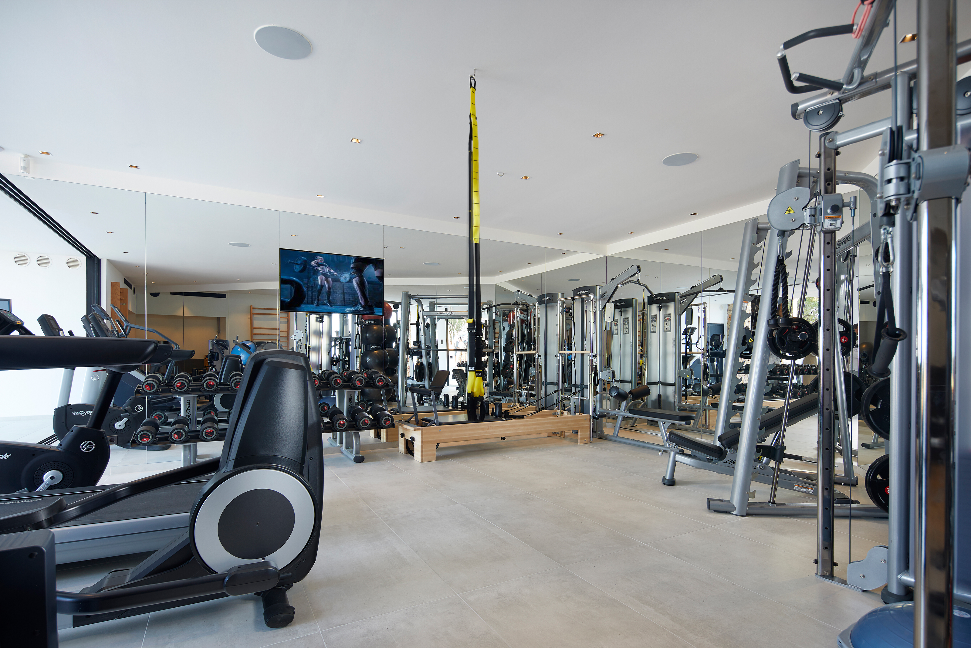 Salle de sport spacieuse avec carrelage de sol élégant et équipements sportifs.